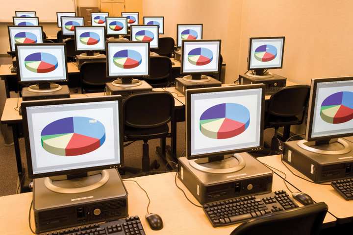 Una habitación llena de computadoras compartiendo la misma pantalla