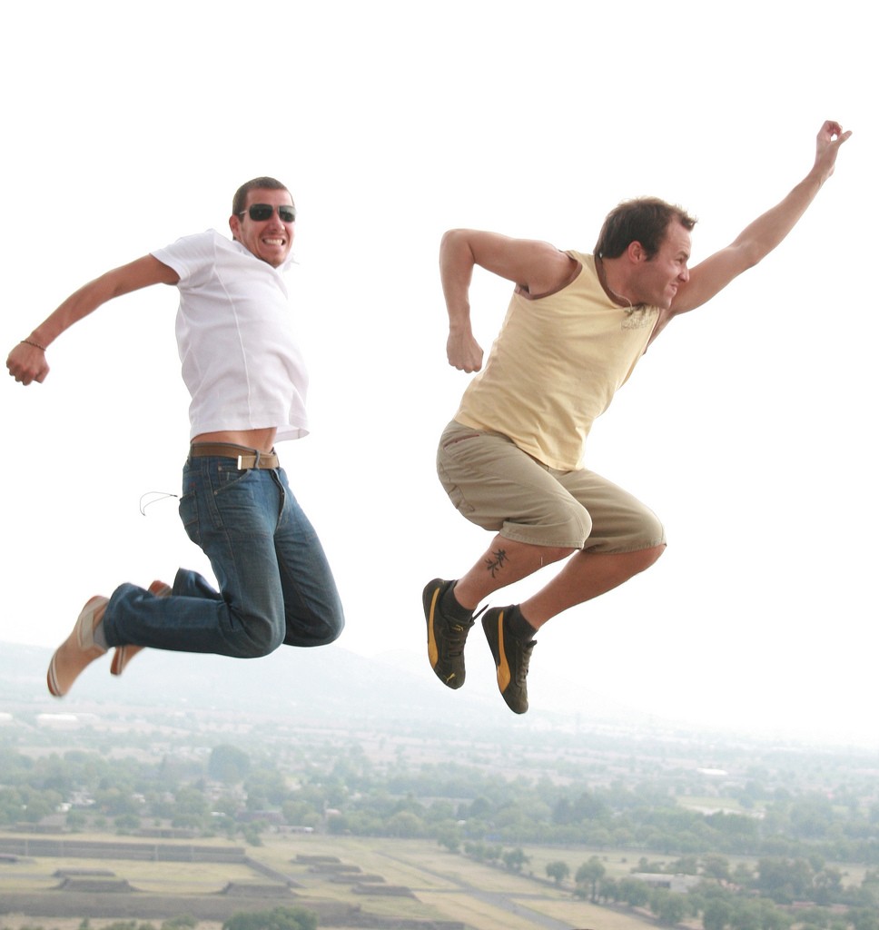 Dos tardíos veintañeros saltando alto en el aire al aire libre (No preguntes)