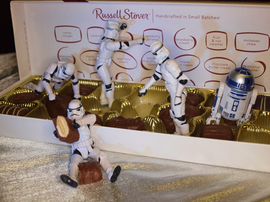 Droide de Star Wars y juguetes jugando en una caja de chocolates (No preguntes)