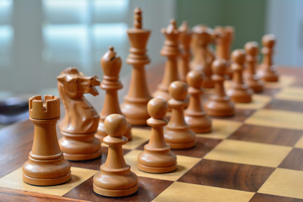 Piezas de ajedrez alineadas en un tablero al inicio de una partida