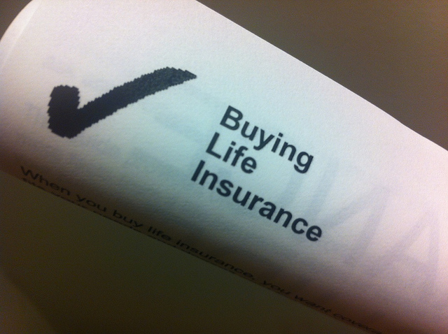 Rolled up paper document with the heading "Buying Life Insurance"
