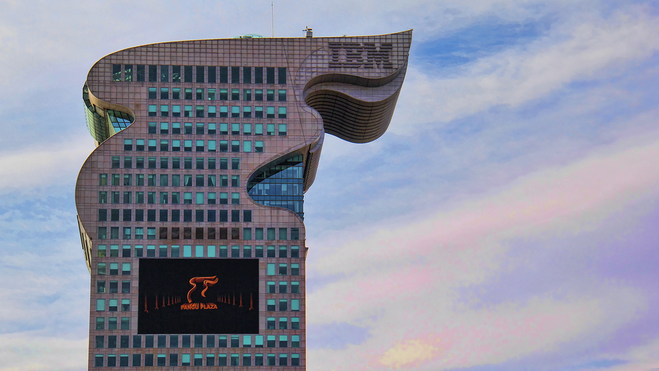 Uma foto mostra um close-up do Dragon Building, a sede da I B M com sede na China, contra um céu azul claro.