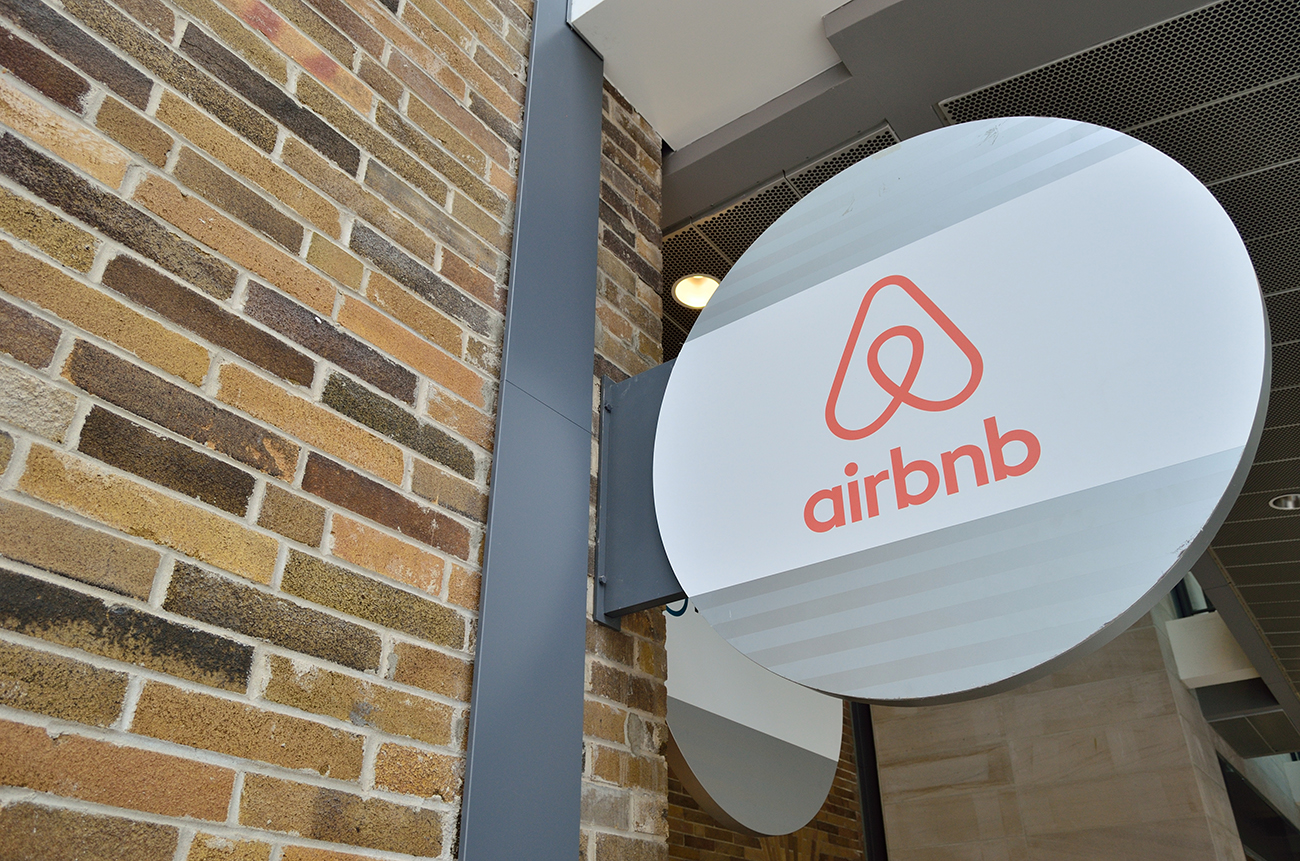 Una foto muestra la firma y el logotipo de la compañía “Airbnb” en la entrada de un edificio de departamentos.