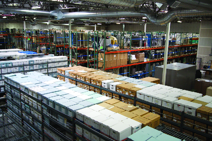 Foto de um chão de fábrica, mostrando pilhas de caixas.