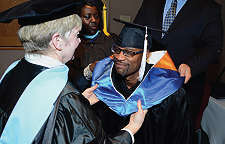 A photograph of a graduate during a college graduation ceremony.