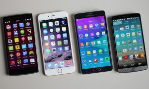 A photograph of four different smartphones, laying side by side on a white background, each displaying their respective homepages.