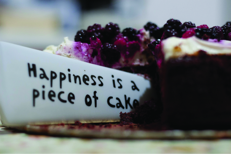 Cette image montre un couteau découpant un morceau de gâteau. Le couteau dit que le bonheur est un jeu d'enfant.