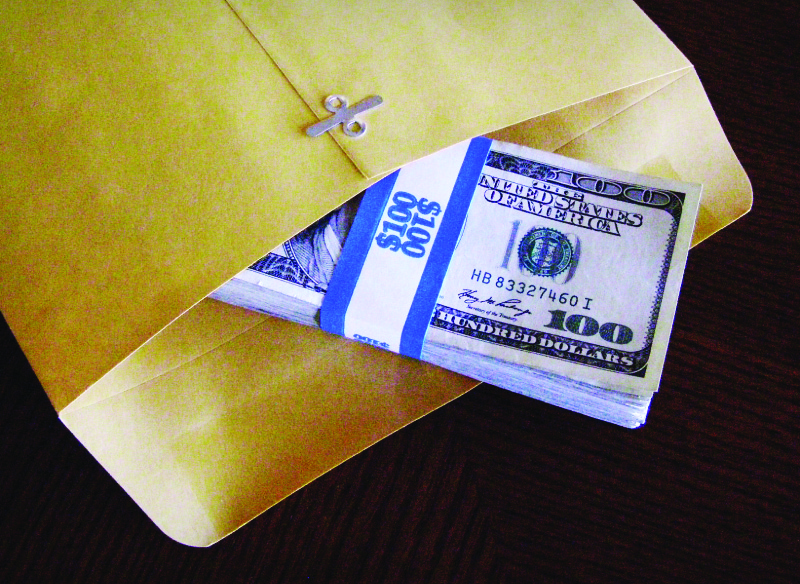 Esta imagem mostra uma pilha de notas de 100 dólares pela metade em um envelope com fecho.