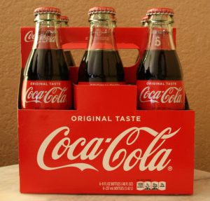 fotografía de un contenedor de botellas de Coca-Cola con el logo en el lateral