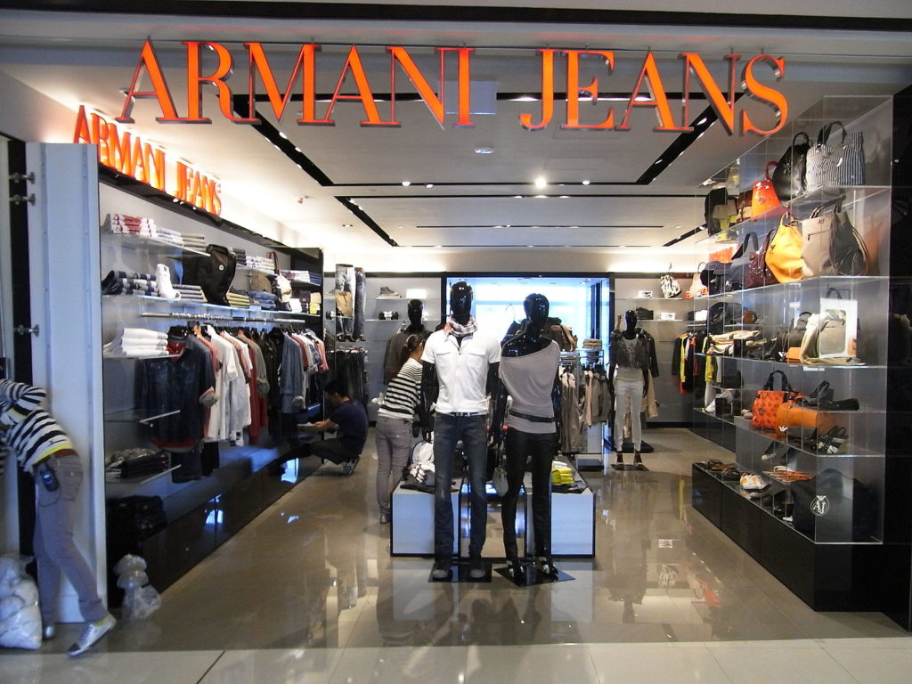 Armani Jeans store. There is merchandise along the exterior walls and a center shelf with merchandise throughout the middle of the store.