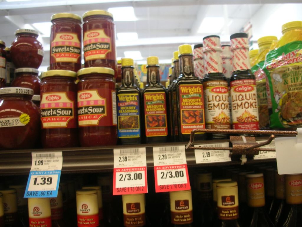 Price tag placed on a shelf in front of an item. Underneath the price tag there is a sales promotion tag that reads "2 for $3".