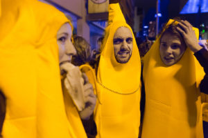Three people wearing banana costumes