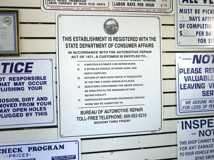 Consumer protection sings on display in an automotive repair shop