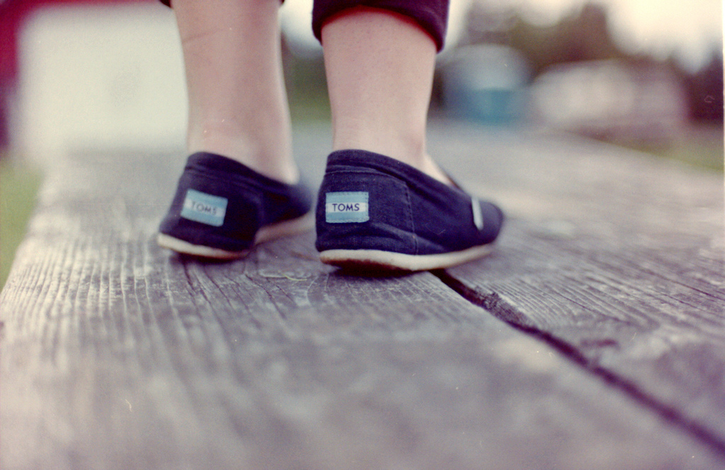 young child wearing a pair of TOMS shoes