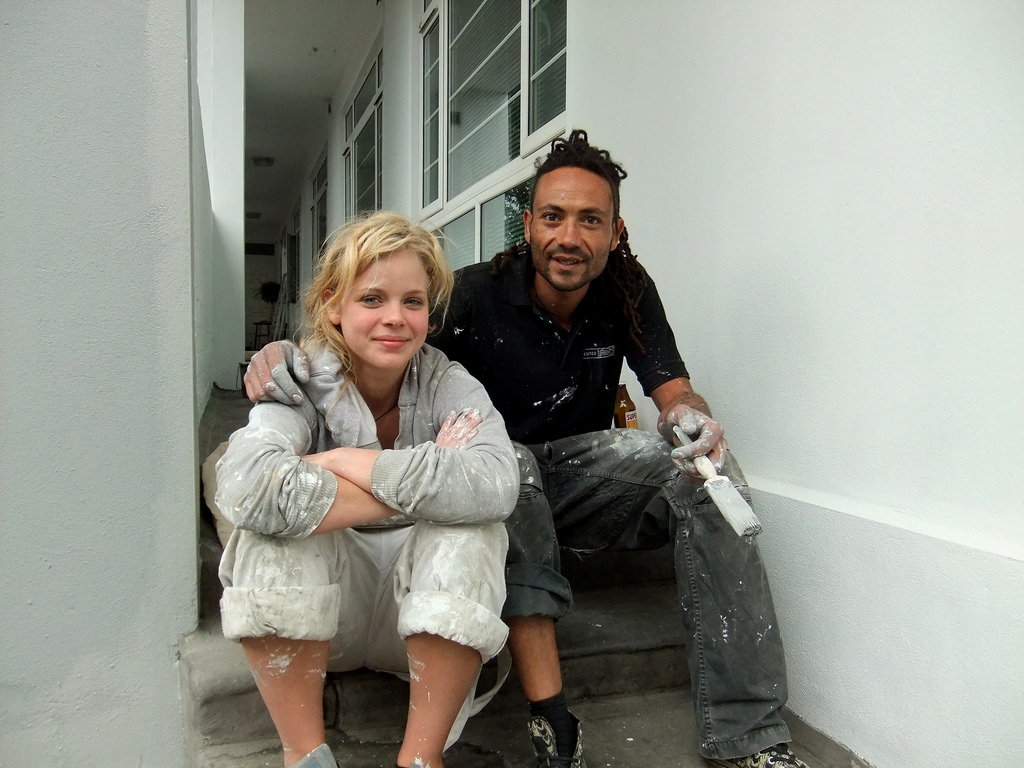 a man and a woman both wearing paint-covered overalls