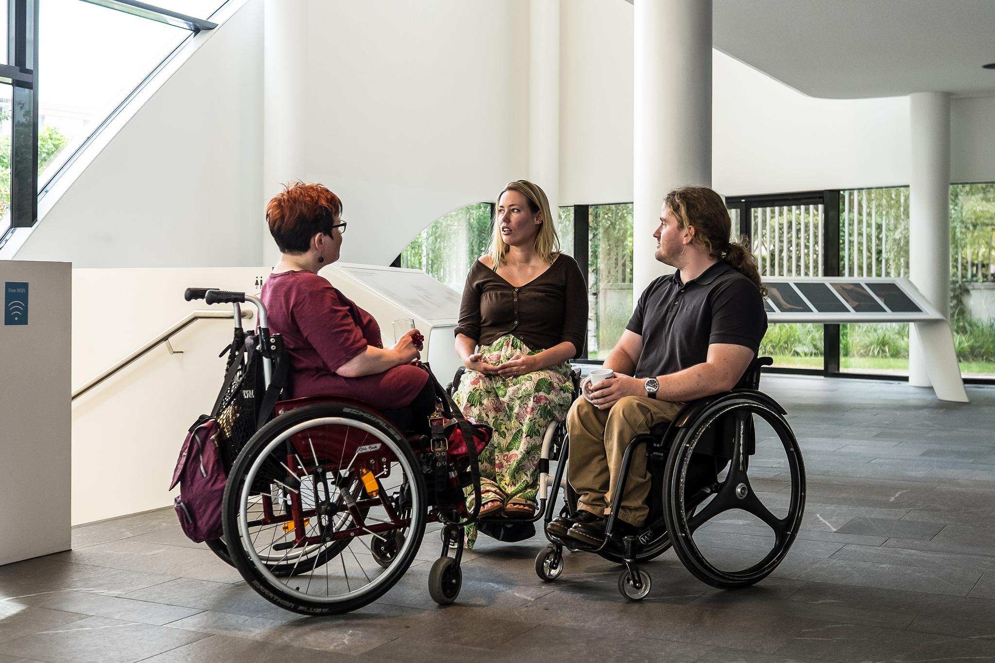 Three women in wheelchairs talking
