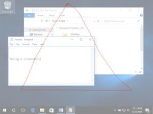 Image of a Windows 10 Desktop with two individual windows open. One is a file finder and the other is a textbook. In front of them both is a large red triangle, indicating that there is a screenshot using the snipping tool in progress.