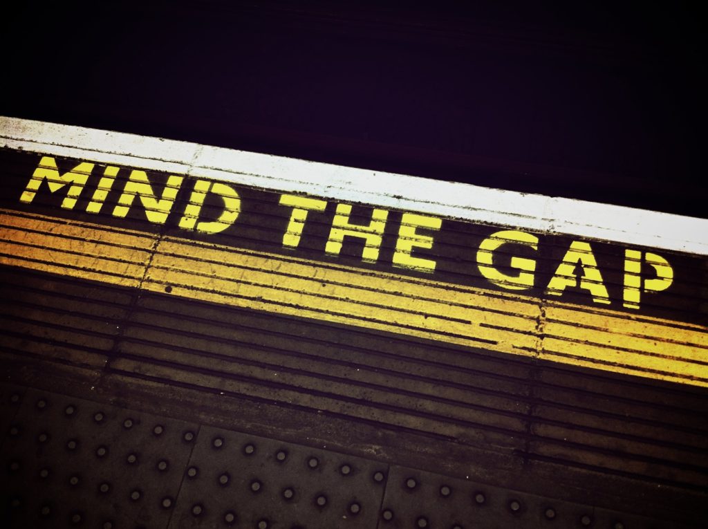 Photograph of the floor of an underground train station. It says "mind the gap" on the floor.