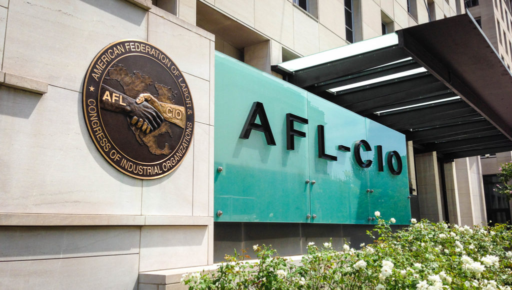 Photograph of the AFL-CIO Headquarters in Washington, D.C. The building has an image of two hands shaking in front of a map of the United States. One hand is labelled AFL, the other is labelled CIO.