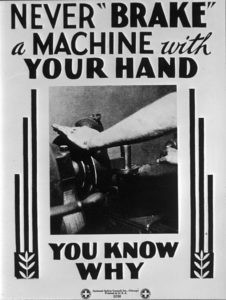 Poster showing a worker's hand placed on top of a piece of machinery. "Never Brake a Machine with Your Hand, You Know Why".