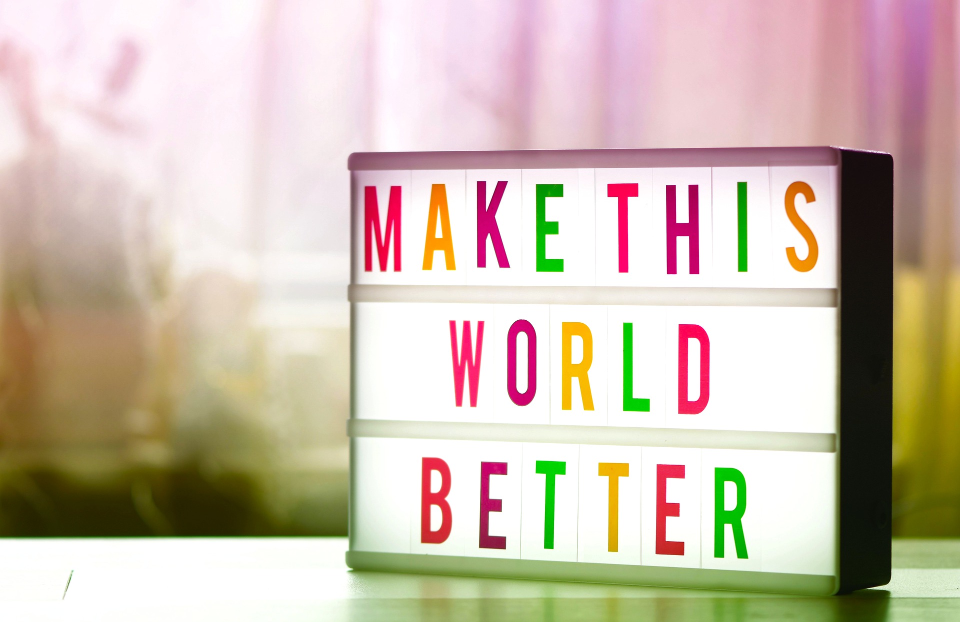 Photograph of a sign board reading "Make this world better."