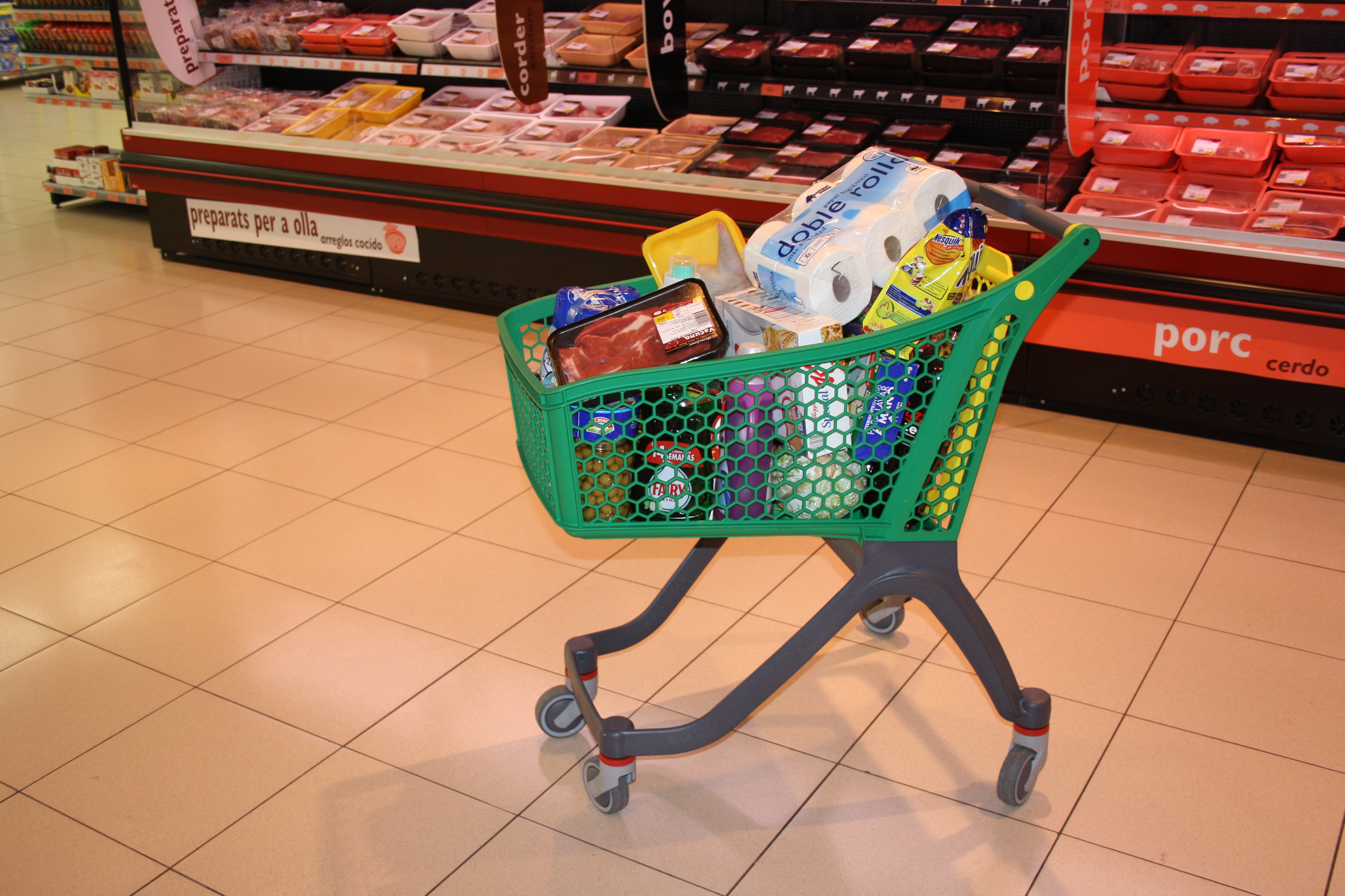 A shopping cart filled with common household goods and groceries.
