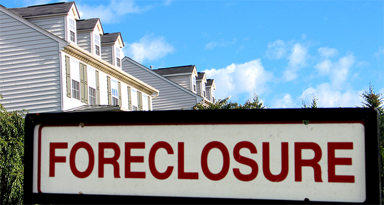 A large sign in front of a house that says Foreclosure