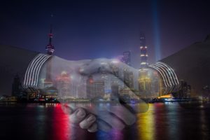 Image of a handshake and buildings in Shanghai, China.
