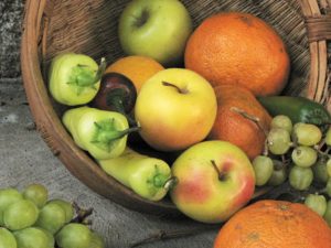 Basket of apples, citrus fruit, grapes, and chilies.