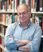 Daniel Kahneman standing by shelves of books