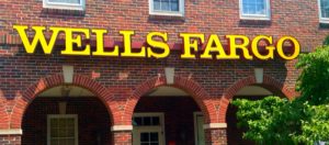 Picture of the front of a brick building with arches with the Wells Fargo name is large yellow letters.