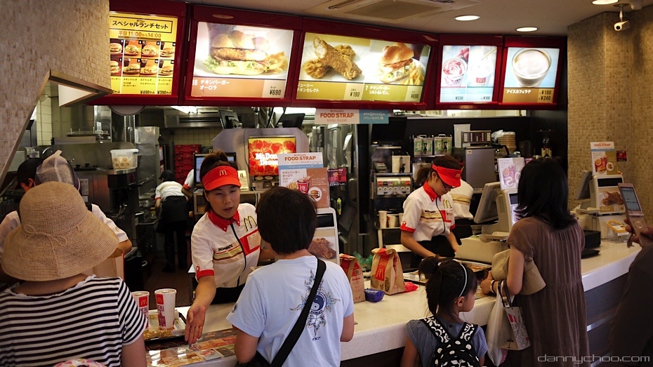 The counter at a busy McDonald's restaurant, with employees taking orders from customers and delivering food.