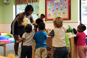 Young lady playing with young children in a child care facility