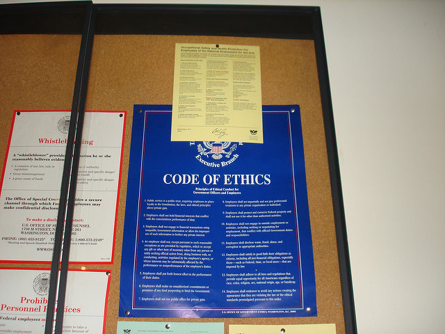 A bulletin board showing documents on whistleblowing and the Code of Ethics from the US Sentencing Commission