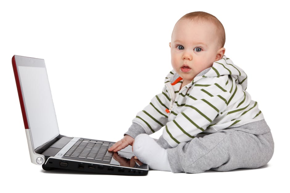 Baby appearing to type on a laptop