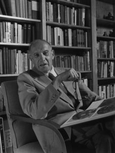 Peter Drucker, sitting on a chair, in a black and white photo.