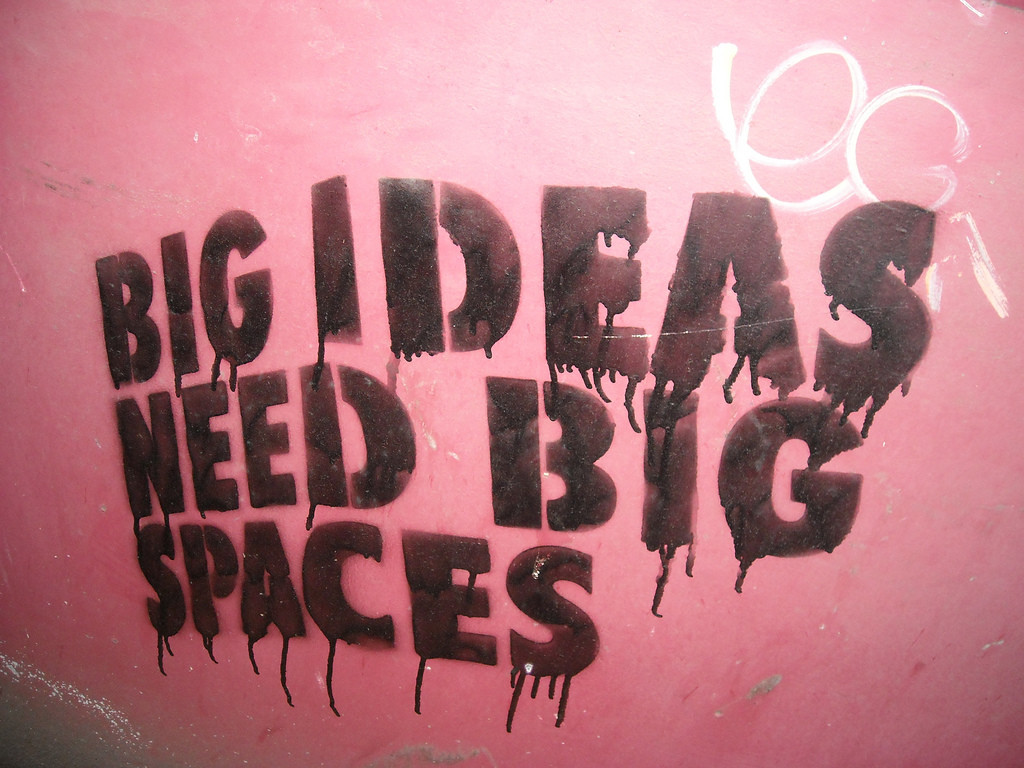 Pink wall with black block letters that read "Big Ideas Need Big Spaces."