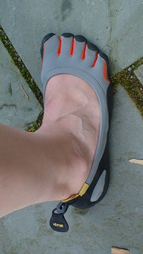 Photo of a man's leg and foot. He's wearing a gray Five Fingers shoe, which "fits hims like a glove."