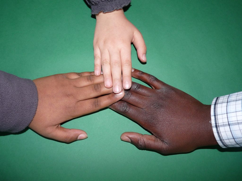 three individuals putting their hands together