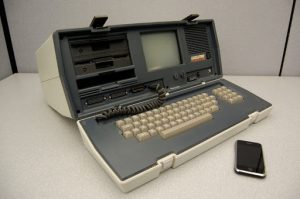 Clunky computer from the early 80s sits next to an iPhone.
