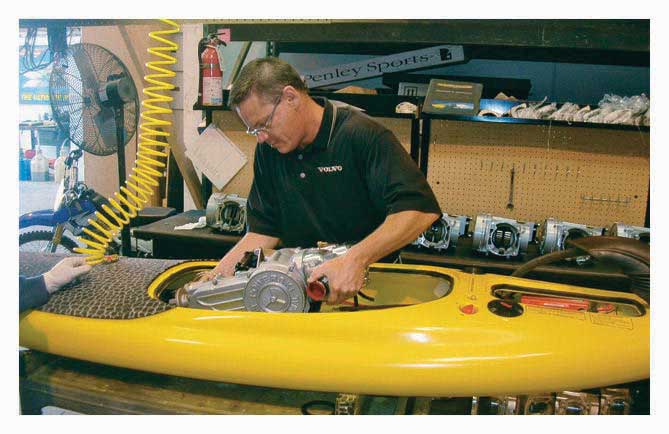 Photo shows a man installing equipment in a yellow PowerSki Jetboard.