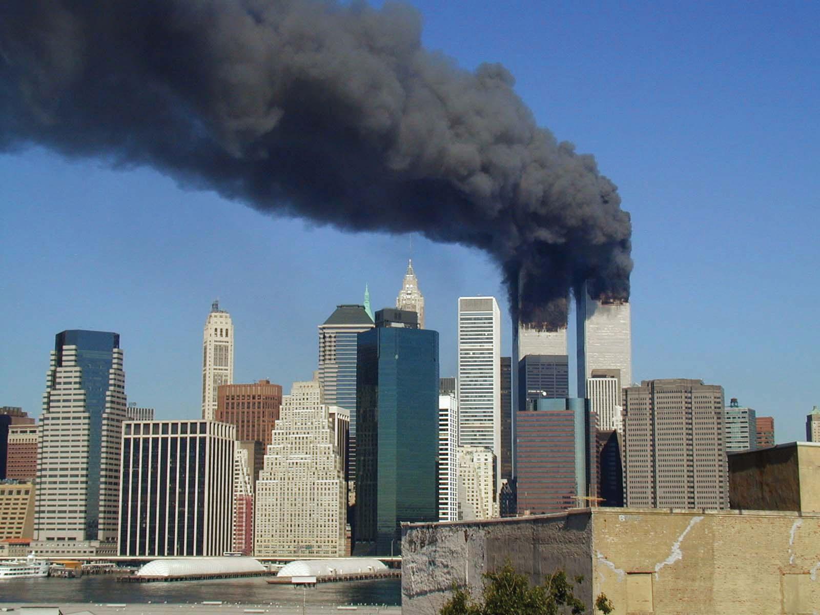 New York city skyline; two buildings have massive plumes of black smoke rising from them.