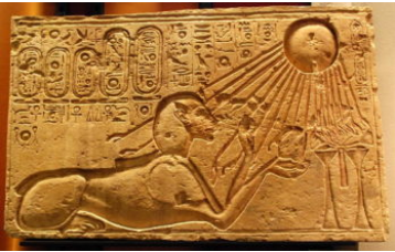 A carved stone relief of a sphinx under a sun, whose rays are shining onto the sphinx. Both are surrounded by hieroglyphics.