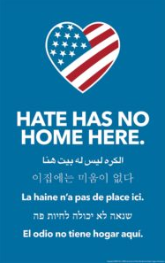 Sign that has the American flag in the shape of a heart and the text "hate has no home here" in English and five other languages. 