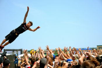 A man is shown diving into a crowd of people with up-stretched hands. Photo title: Trust Dive. 