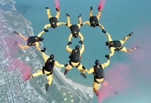 A group of eight people skydiving while holding hands to form a figure eight