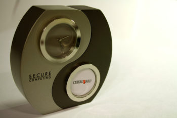 Photo of a clock with a yin yang pattern on the front. One section is labeled Secure Computing; the other section is labeled CyberGuard. Secure Computing acquired CyberGuard. 