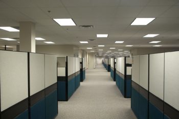Photo of a completely empty office building with many rows of cubicles, also empty, shown after all the workers were laid off.