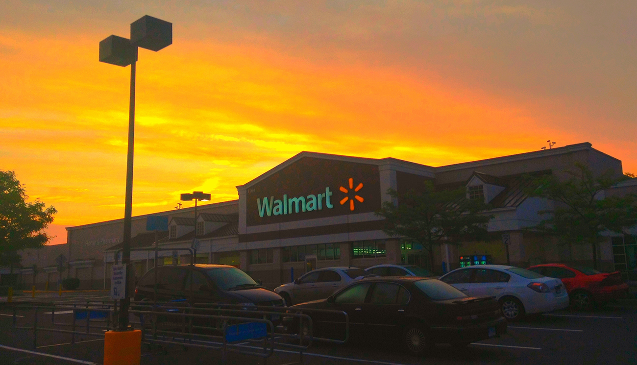 Una fotografía muestra la entrada frontal de una tienda Walmart.