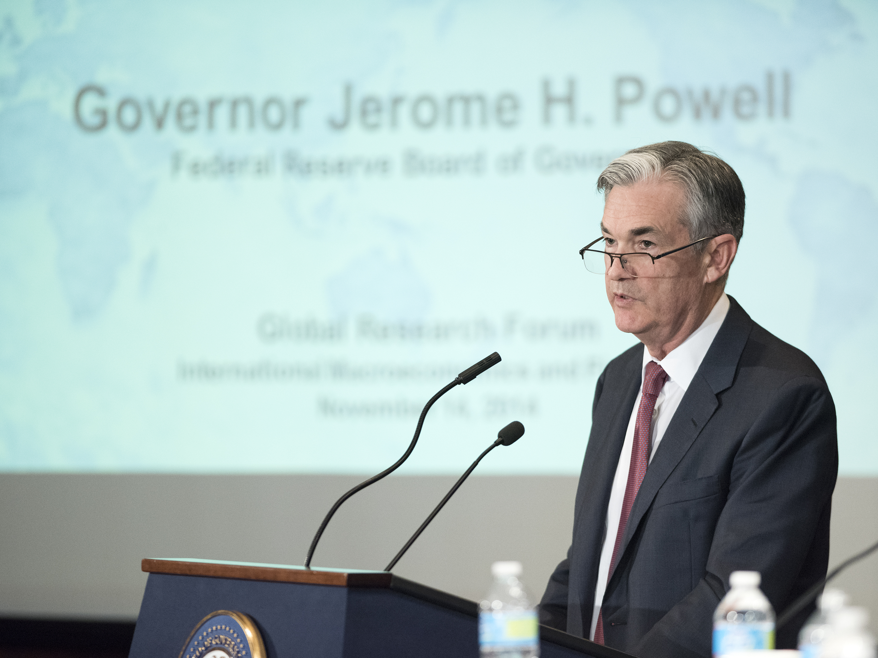 Une photographie montre le président de la Fed Jay Powell s'exprimant à une tribune.